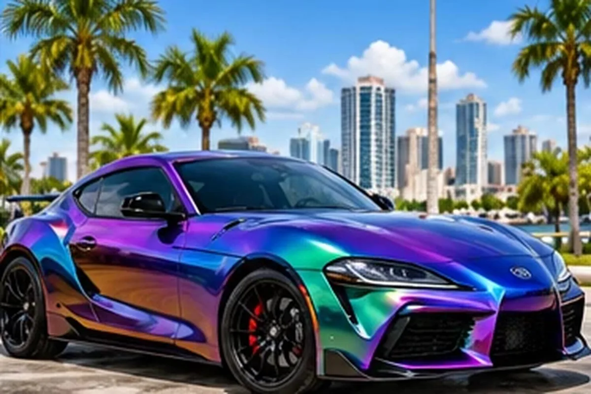 Color-shift purple and teal wrapped sport sedan against the Los Angeles skyline